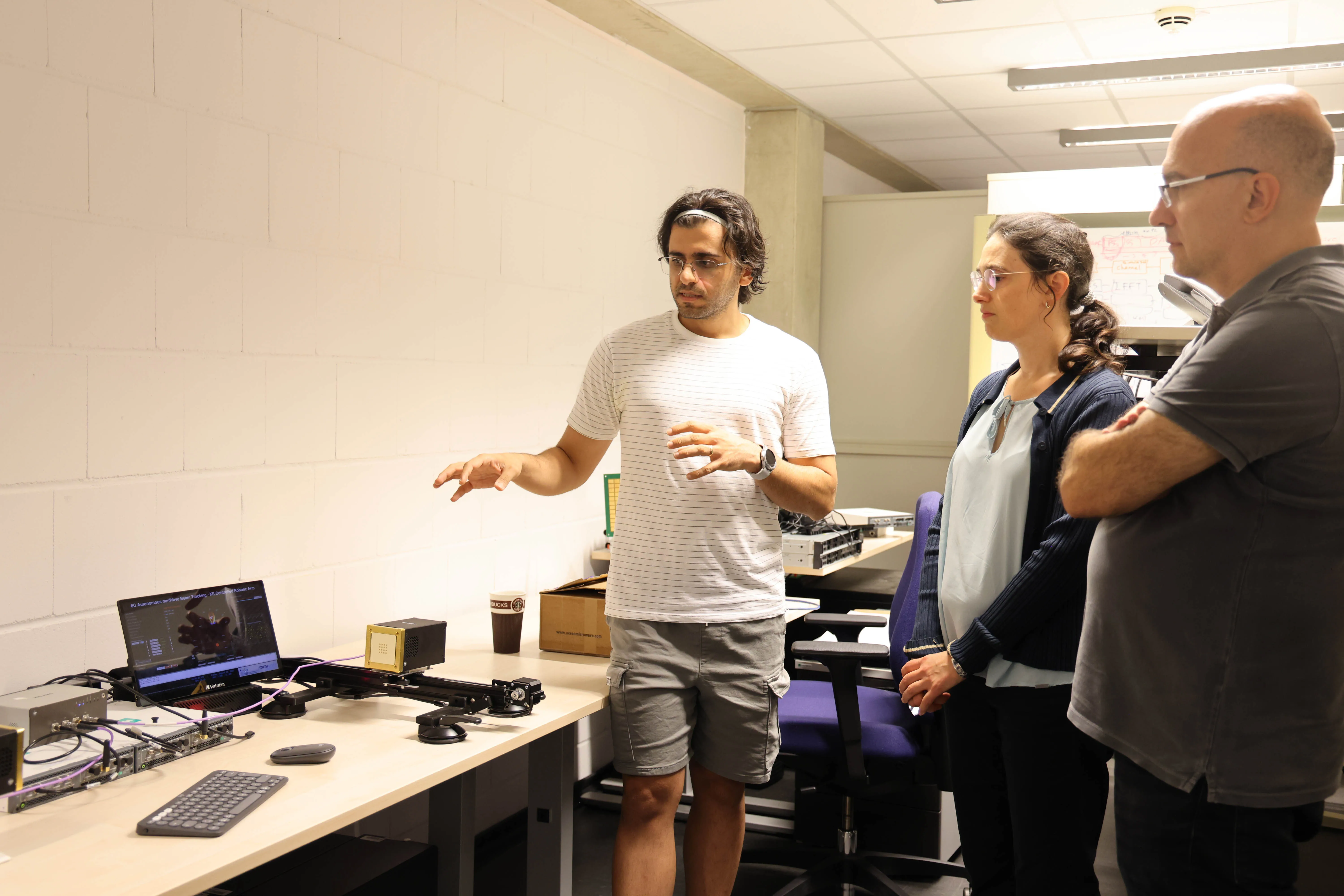 Researchers discuss an experimental wireless systems demonstration in the DSP laboratory.